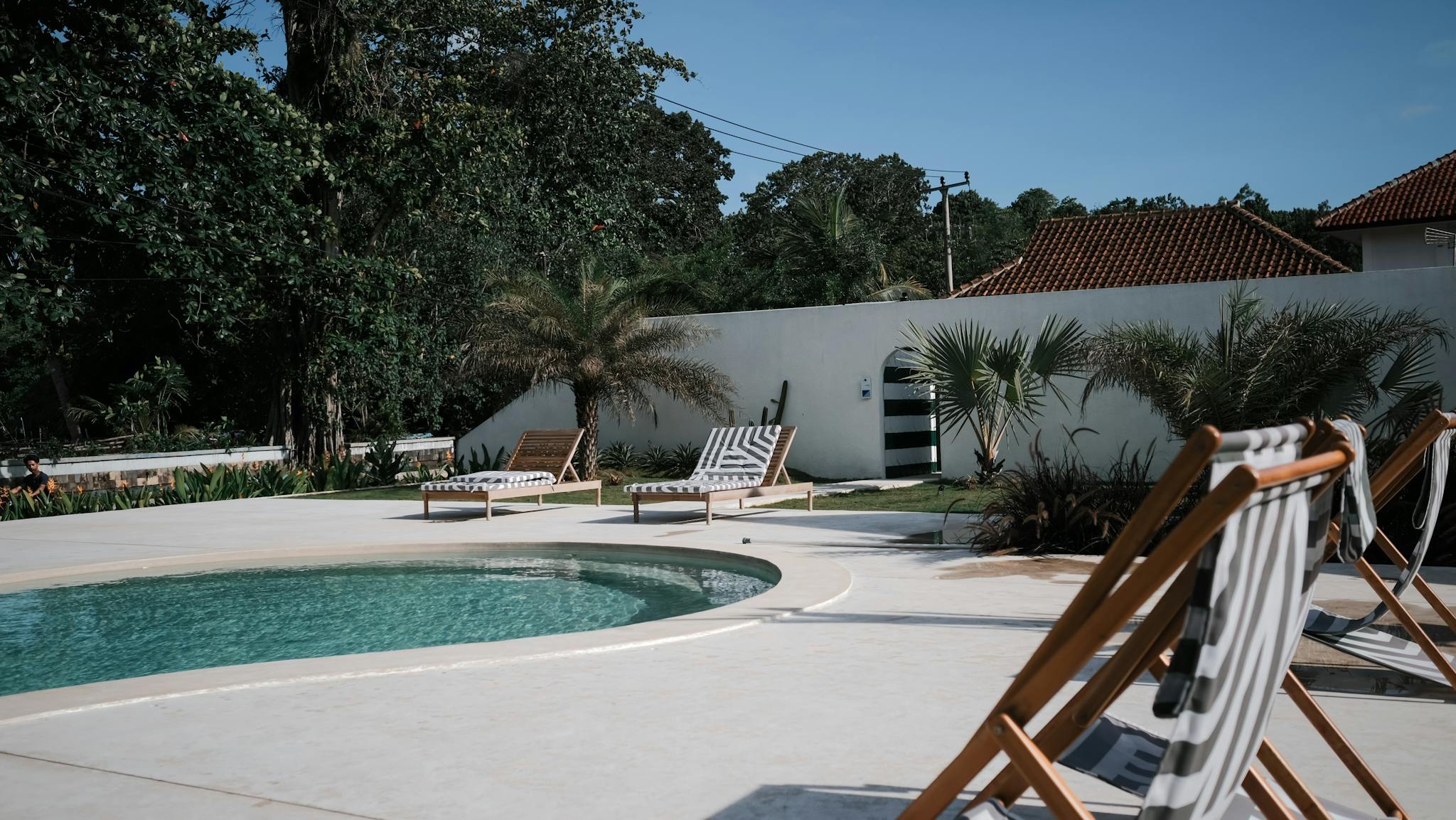 Experience luxury and tranquility by the sunlit pool, surrounded by nature and comfort.